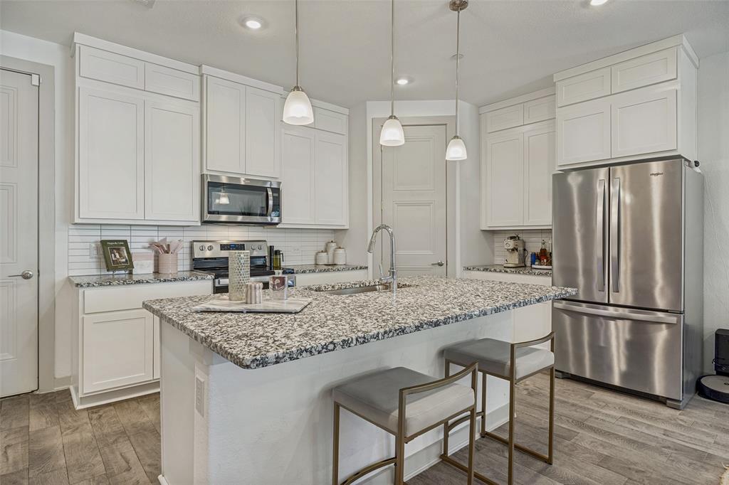 1650 Jessica Lane Allen, TX 75002 - Photo 8 of 25 a kitchen with kitchen island granite countertop a sink a center island and stainless steel appliances
