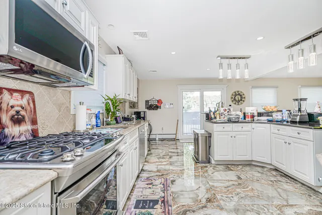 a kitchen with stainless steel appliances granite countertop a stove a sink and a microwave