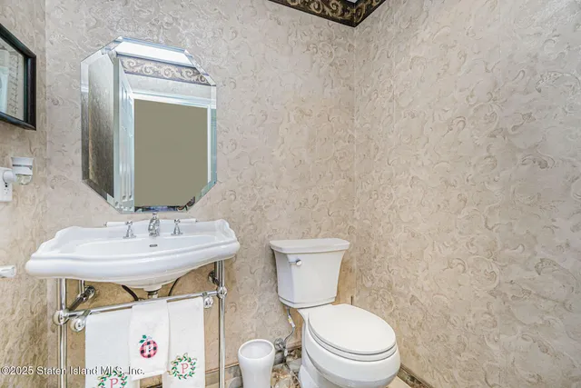 a bathroom with a toilet sink vanity and mirror