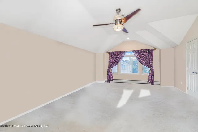 an empty room with ceiling fan and window
