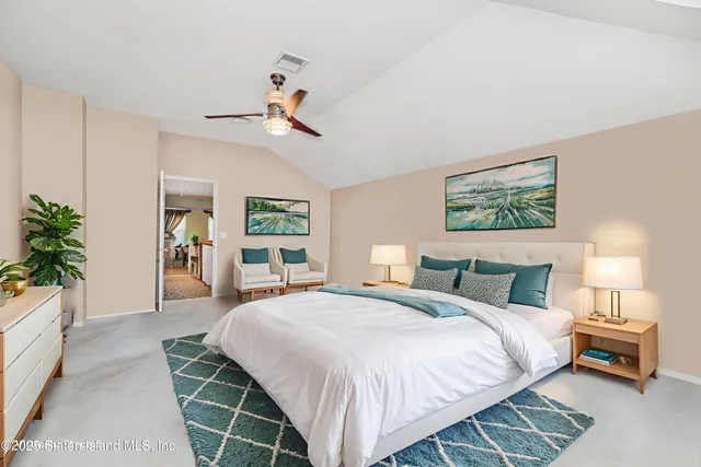 a bedroom with a large bed and a chandelier