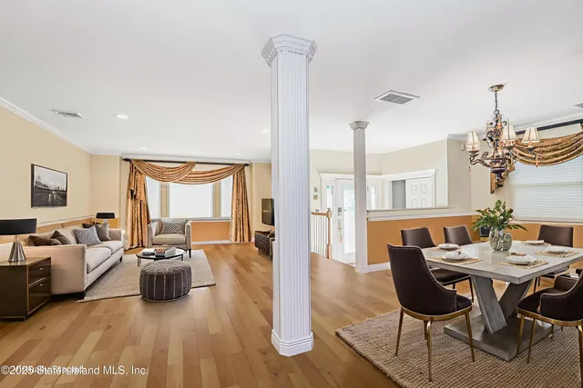 a living room with furniture a chandelier and a dining table