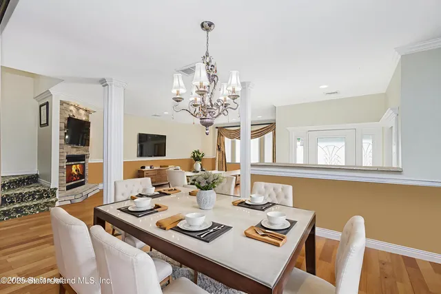 a view of a dining room with furniture a chandelier and wooden floor