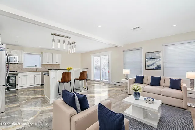 a living room with furniture and kitchen view