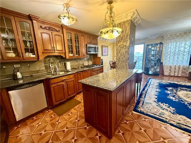 a kitchen with stainless steel appliances granite countertop a sink stove and refrigerator
