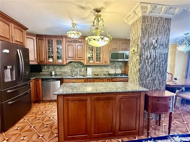 a kitchen with stainless steel appliances granite countertop a stove a sink and a wooden cabinets
