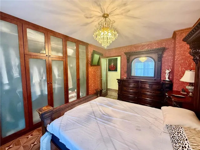 a bedroom with a large bed and a chandelier
