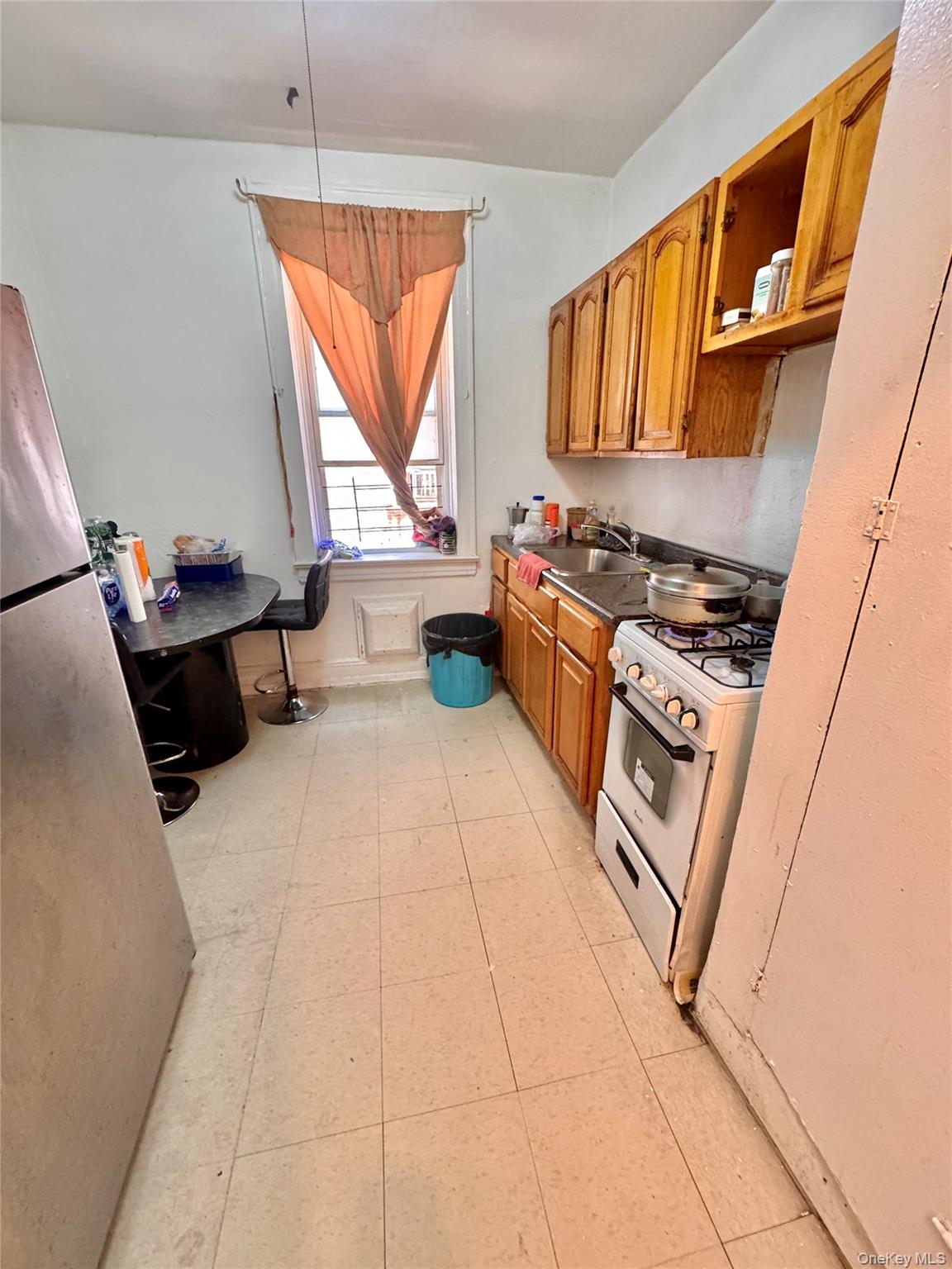 33-54 99th Street Queens, NY 11368 - Photo 17 of 41 a kitchen with stainless steel appliances a stove a sink and a refrigerator