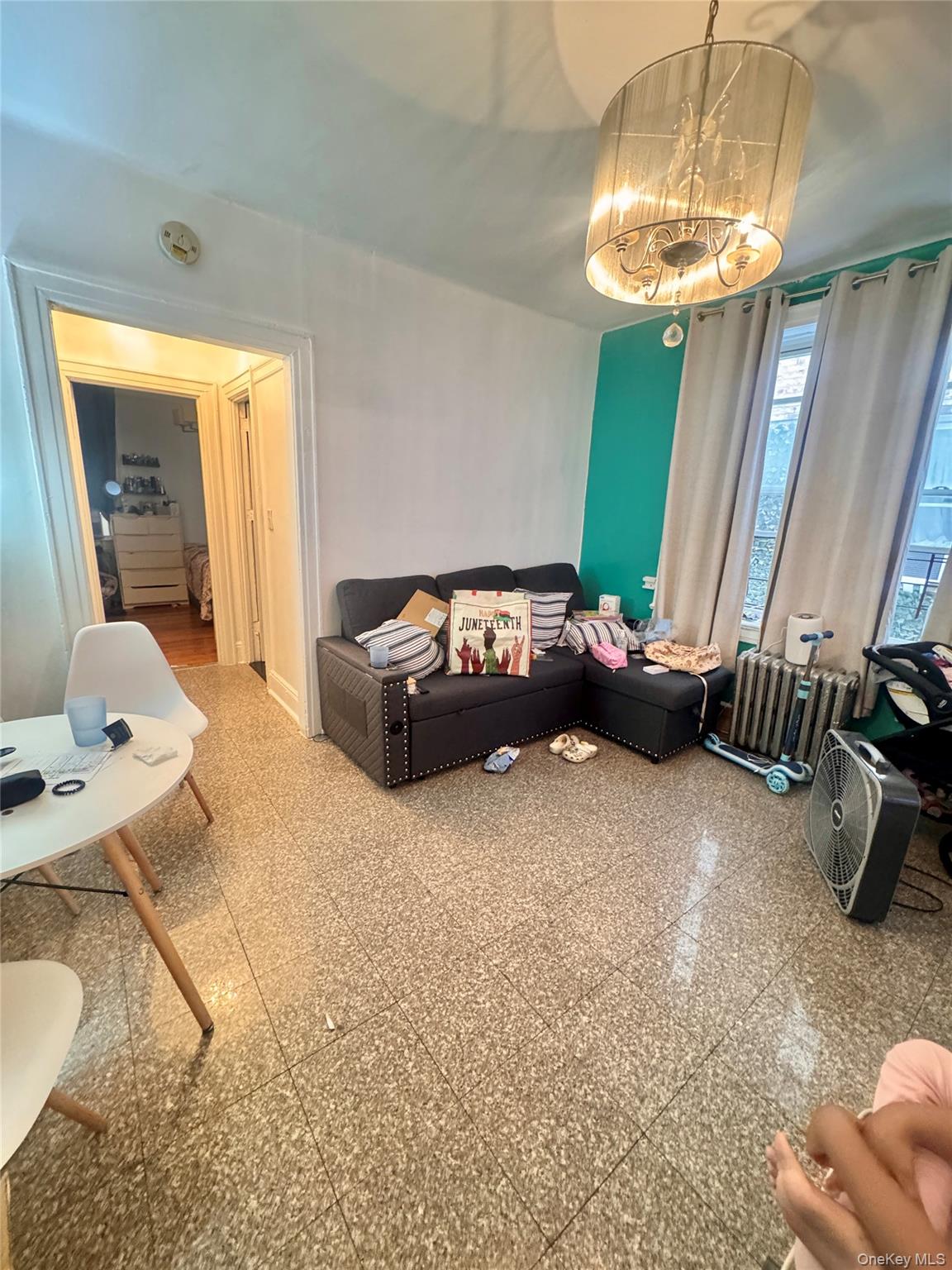 33-54 99th Street Queens, NY 11368 - Photo 40 of 41 a living room with furniture and a chandelier