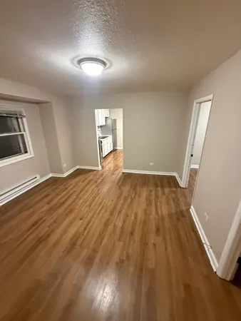 a view of empty room with wooden floor