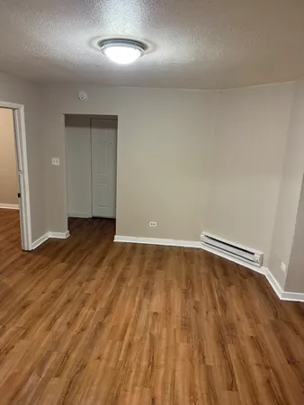 a view of an empty room with wooden floor