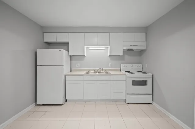 a kitchen with a stove top oven and white cabinets