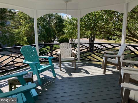 38852 Bayfront Drive Ocean View, DE 19970 - Photo 22 of 28 a view of a patio with table and chairs with wooden floor and fence