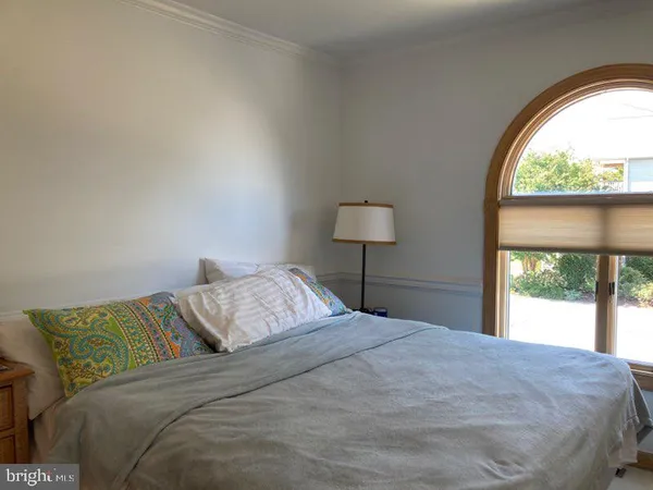 a bedroom with a bed and a large window