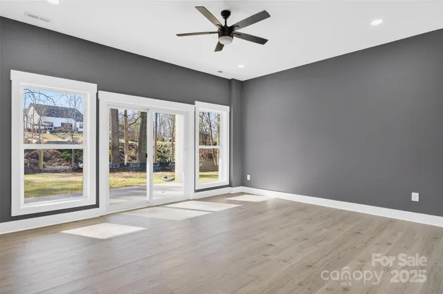 a view of an empty room with a window and a ceiling fan