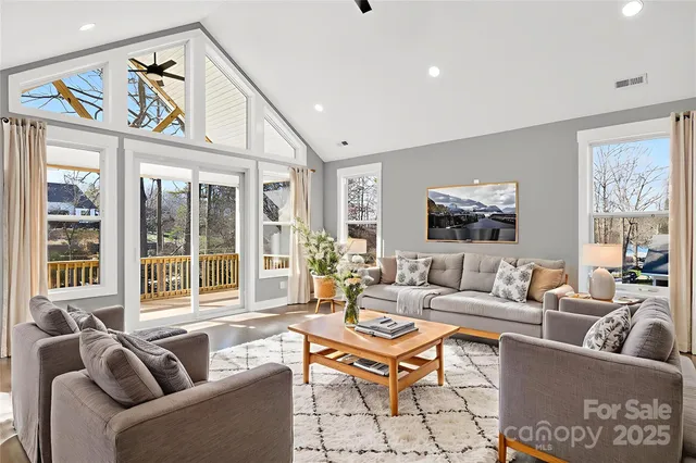 a living room with furniture a large window and a flat screen tv