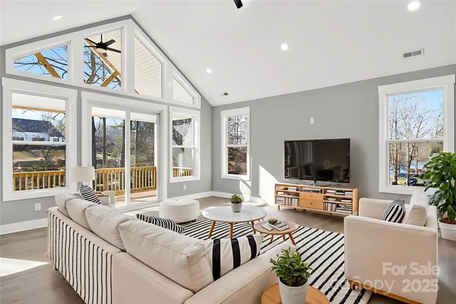 a living room with furniture a flat screen tv and a large window
