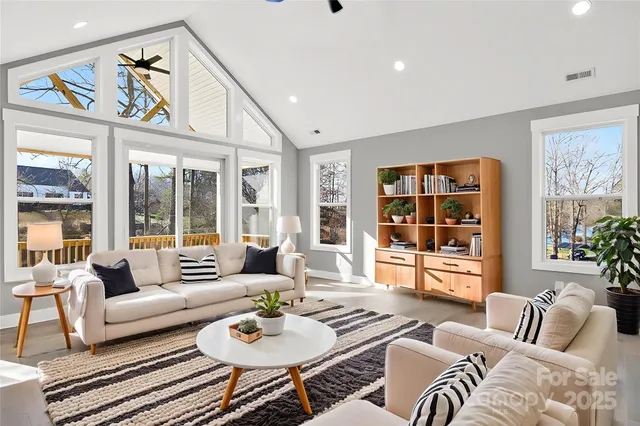 a living room with furniture and floor to ceiling windows
