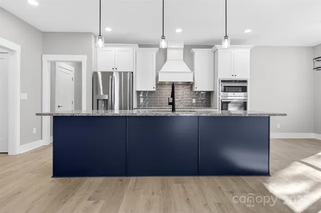 a kitchen with a refrigerator a sink and a cabinets