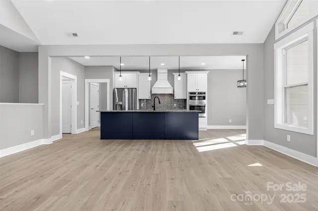 a view of a kitchen with wooden floor and windows