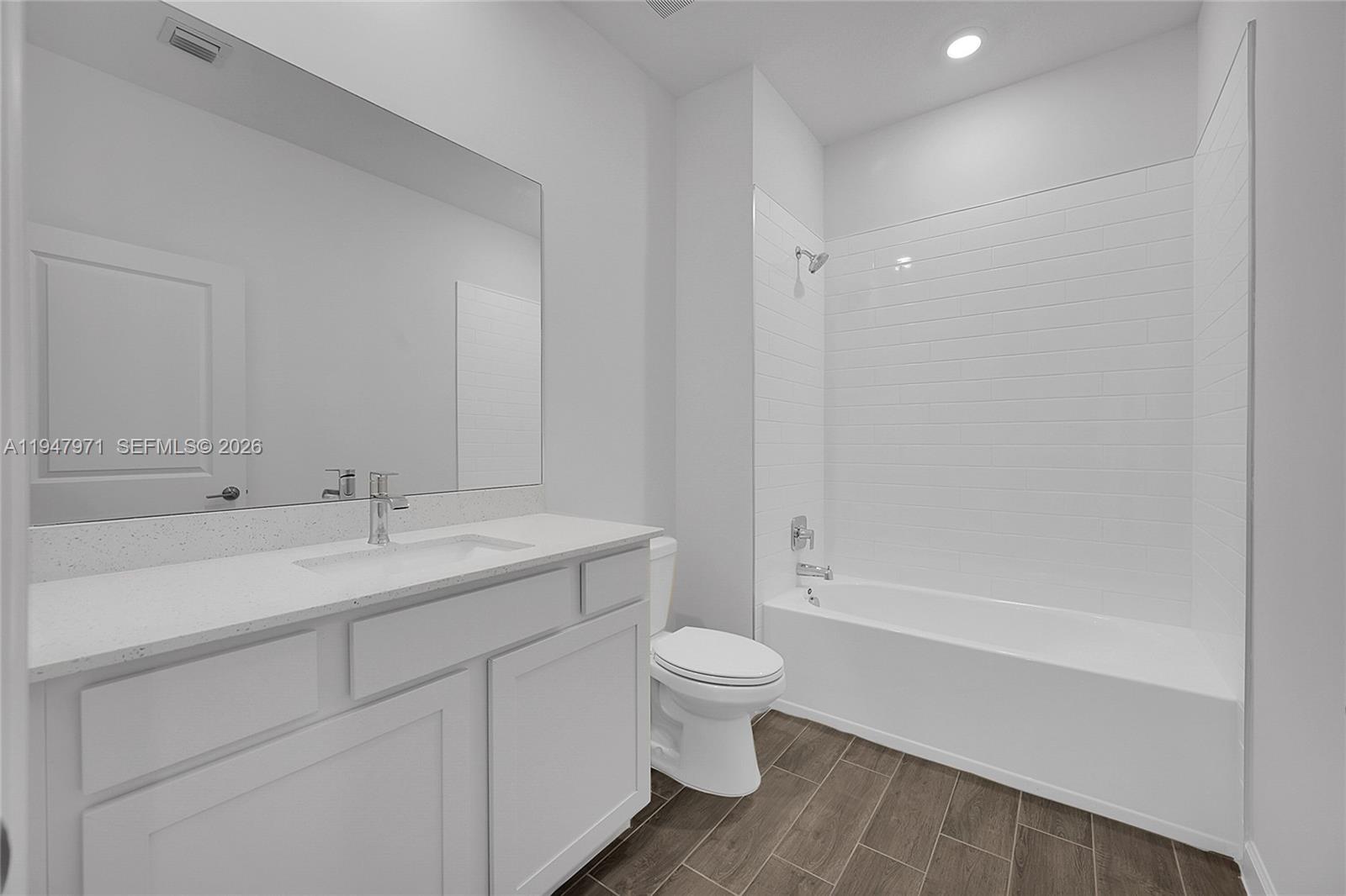 19465 Whispering Creek Road Loxahatchee, FL 33470 - Photo 12 of 22 a bathroom with a toilet a sink a mirror a bathtub and vanity