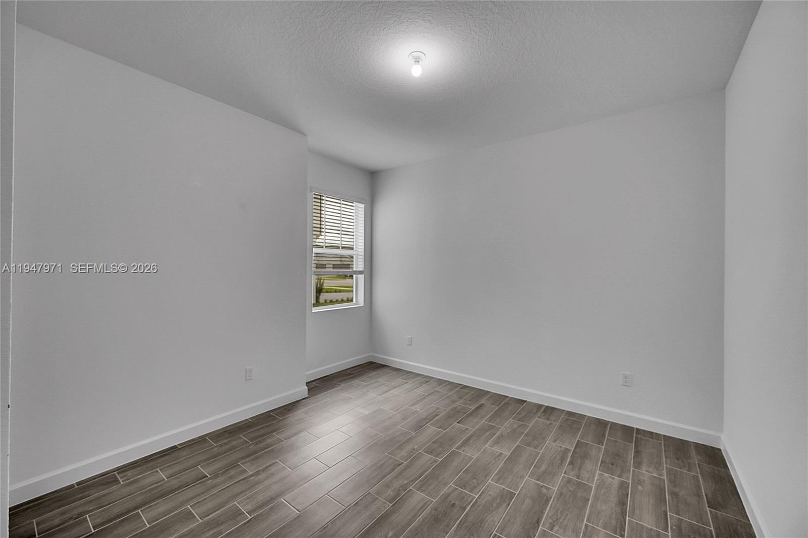19465 Whispering Creek Road Loxahatchee, FL 33470 - Photo 14 of 22 an empty room with wooden floor and windows