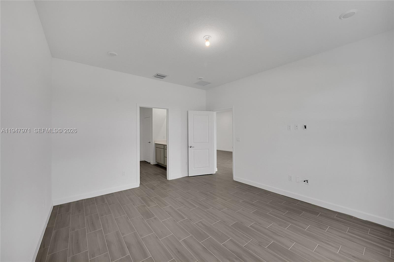 19465 Whispering Creek Road Loxahatchee, FL 33470 - Photo 20 of 22 a view of an empty room with wooden floor