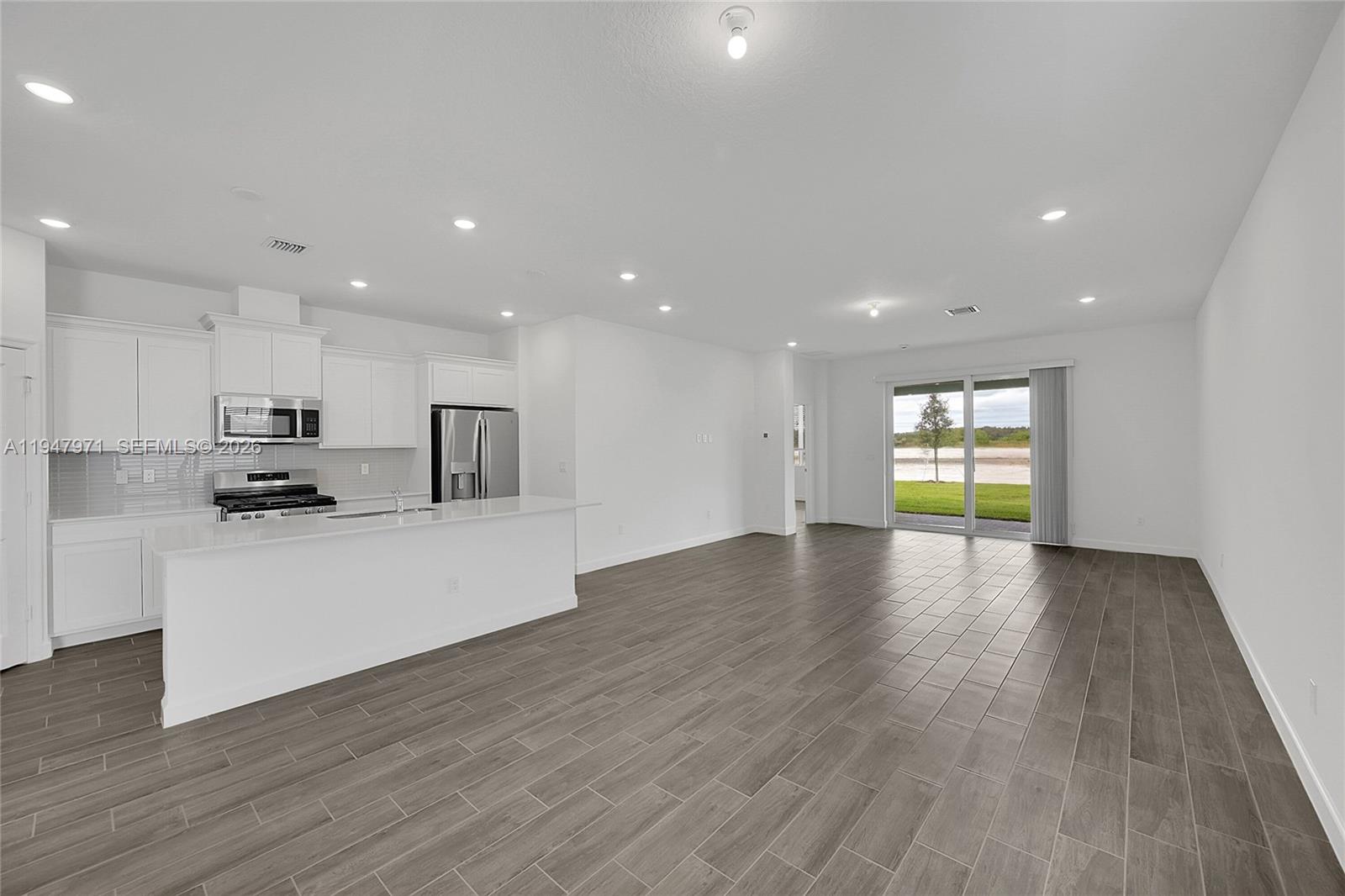19465 Whispering Creek Road Loxahatchee, FL 33470 - Photo 4 of 22 a view of kitchen with cabinets wooden floor and a sink