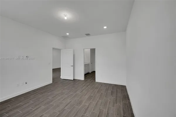 a view of empty room with wooden floor