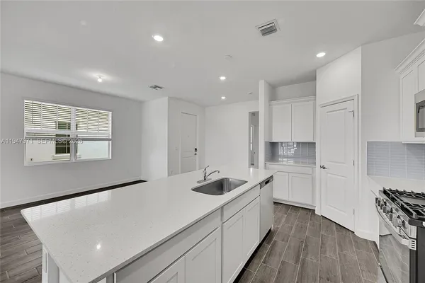 a kitchen with a sink and wooden floor