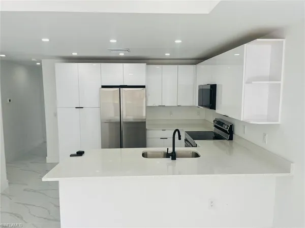 a kitchen with a sink a counter top space cabinets and stainless steel appliances