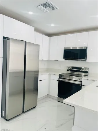 a kitchen with stainless steel appliances a refrigerator and a stove top oven