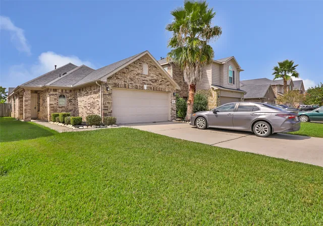 a view of a house with a garden and parking space