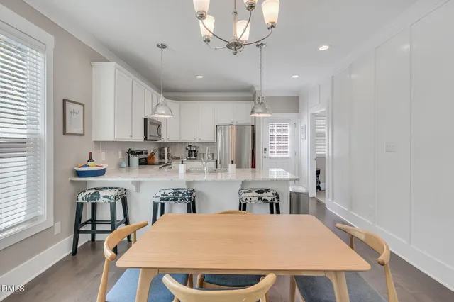 a large kitchen with kitchen island a table and chairs in it