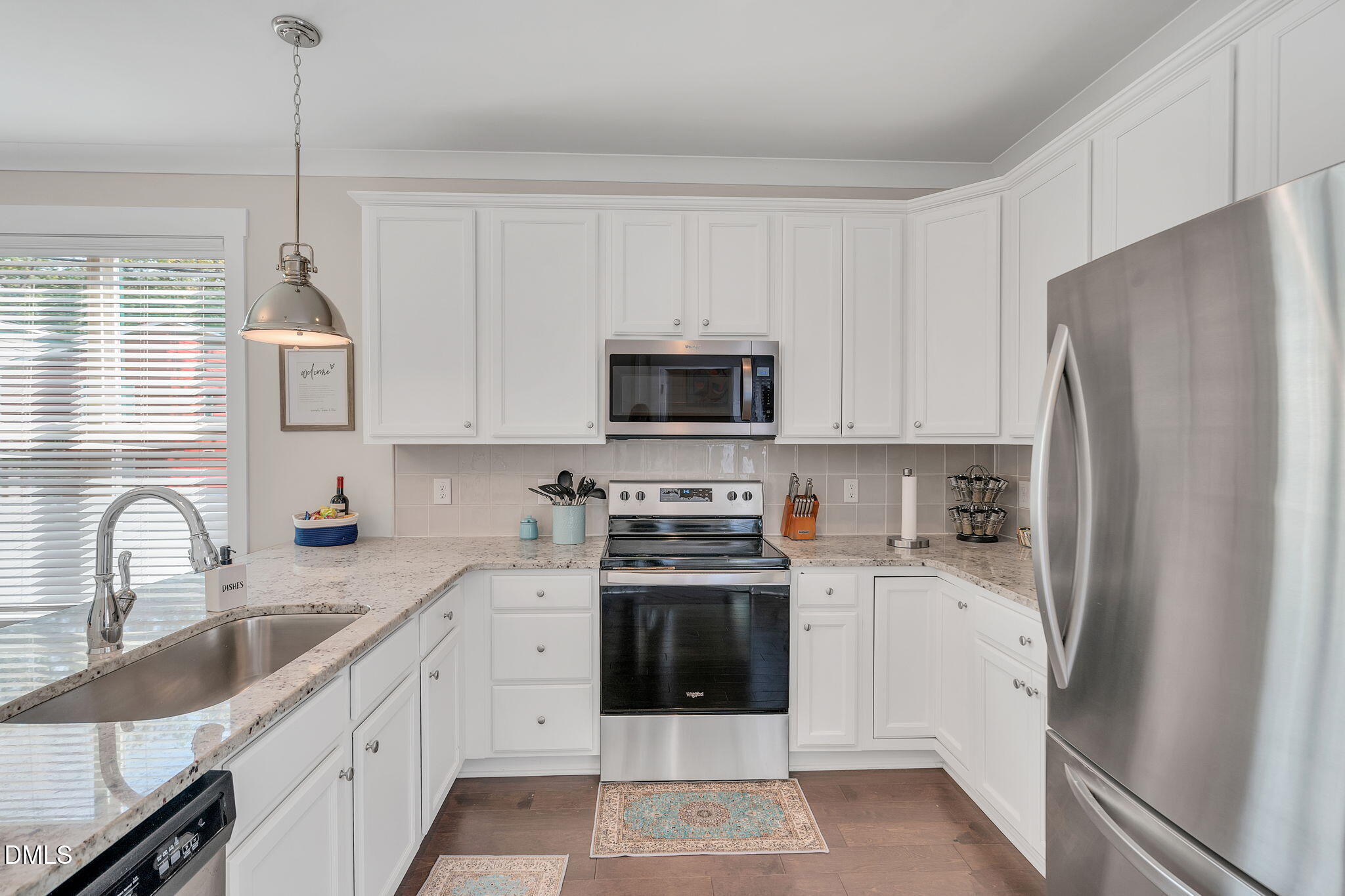 510 Eugene Street Durham, NC 27701 - Photo 14 of 42 a kitchen with stainless steel appliances granite countertop a refrigerator stove a sink and white cabinets