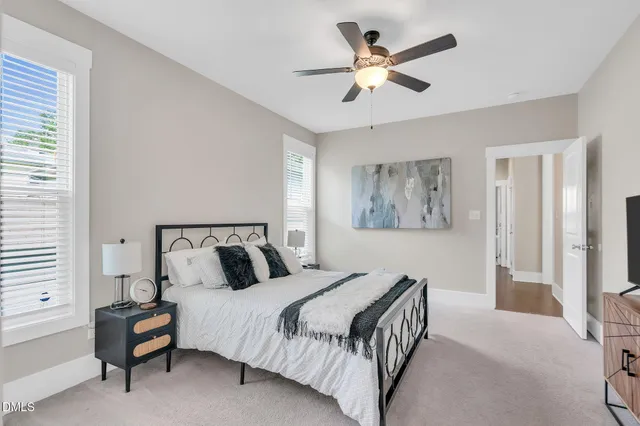 a bedroom with a large bed and a chandelier