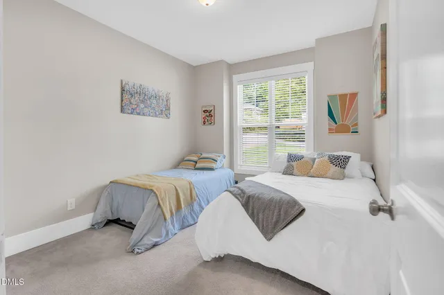 a bedroom with two beds and a window