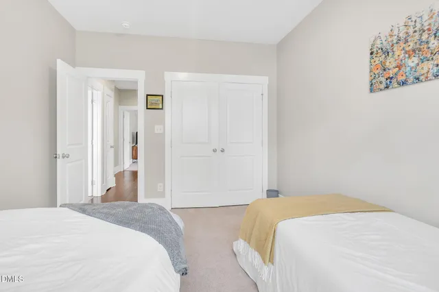 a bedroom with a bed and painting on the wall