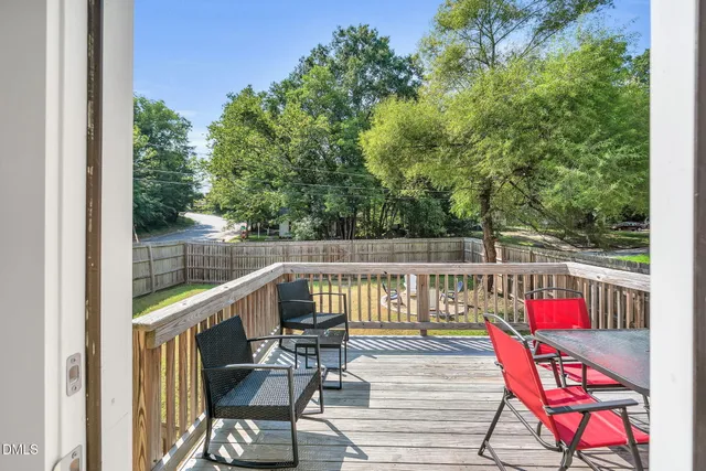 a view of deck with furniture and trees in the background