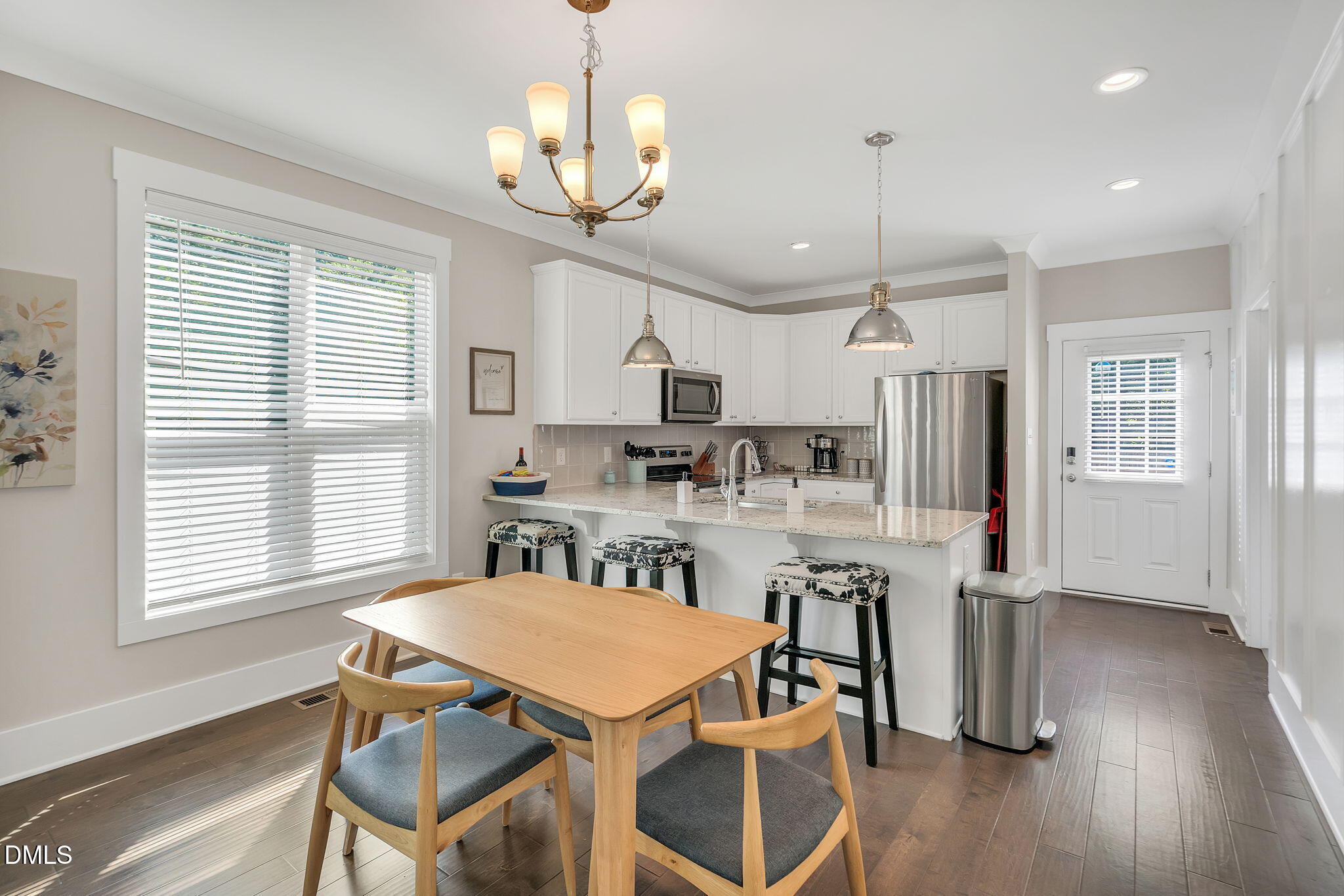 510 Eugene Street Durham, NC 27701 - Photo 10 of 42 a kitchen with stainless steel appliances granite countertop a dining table chairs refrigerator and wooden floor