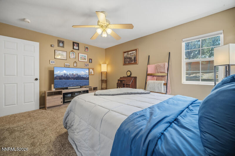 1931 Lousetown Road Reno, NV 89521 - Photo 19 of 51 a bedroom with a bed a chandelier and dresser