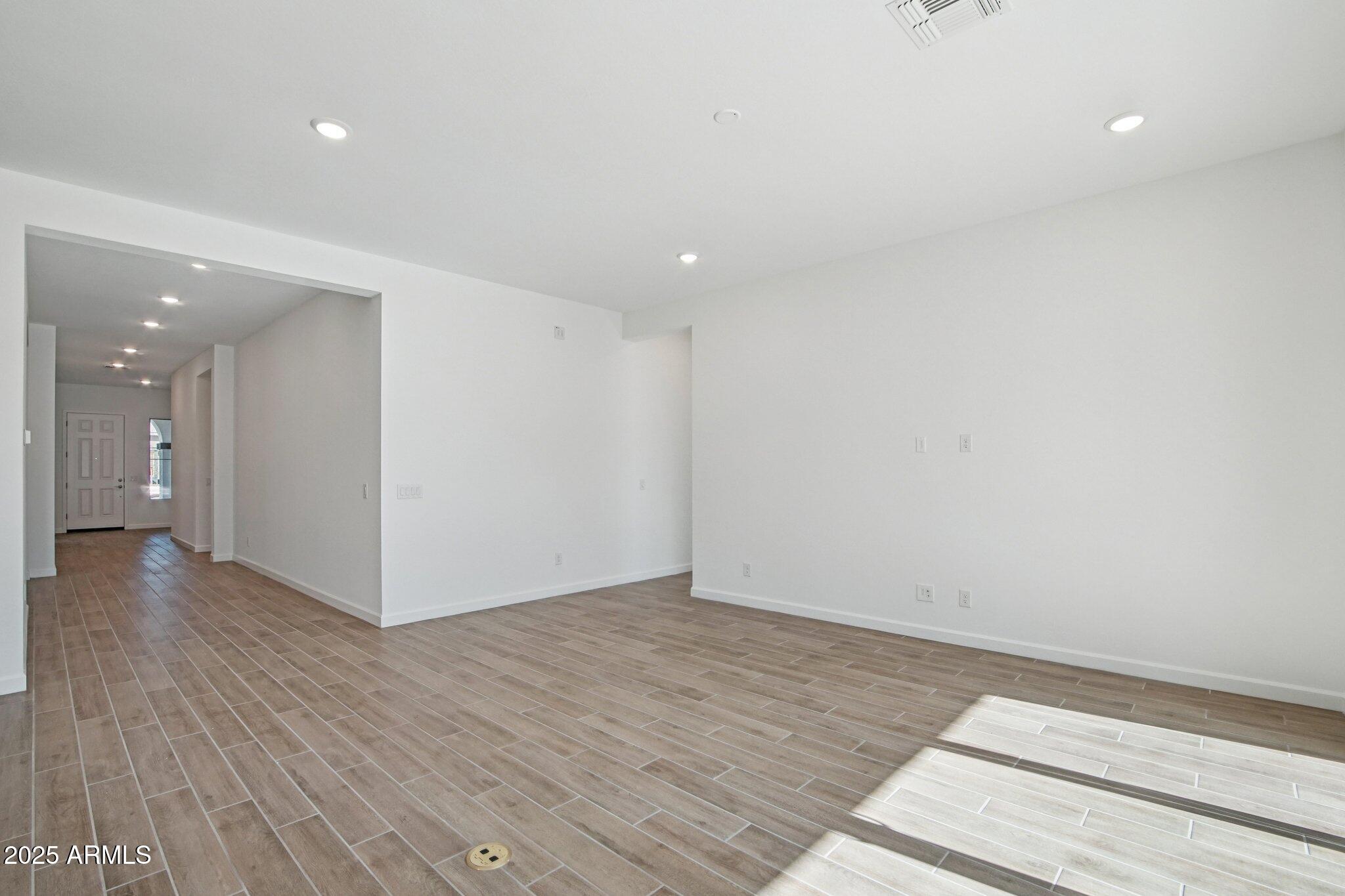 22725 East Saddle Way Queen Creek, AZ 85142 - Photo 11 of 48 a view of an empty room with wooden floor and a window