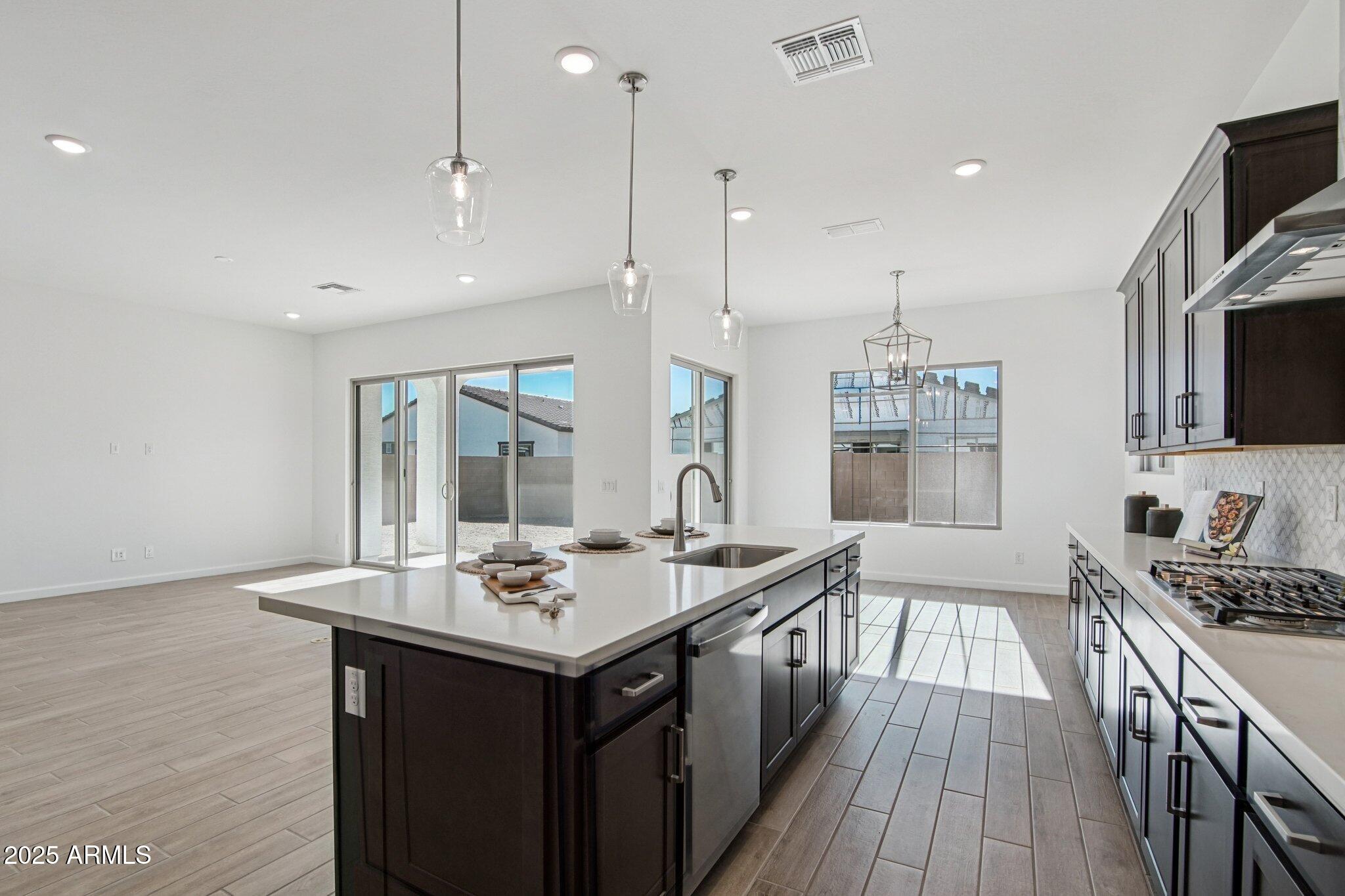 22725 East Saddle Way Queen Creek, AZ 85142 - Photo 14 of 48 a kitchen with stainless steel appliances granite countertop a sink stove and wooden floor