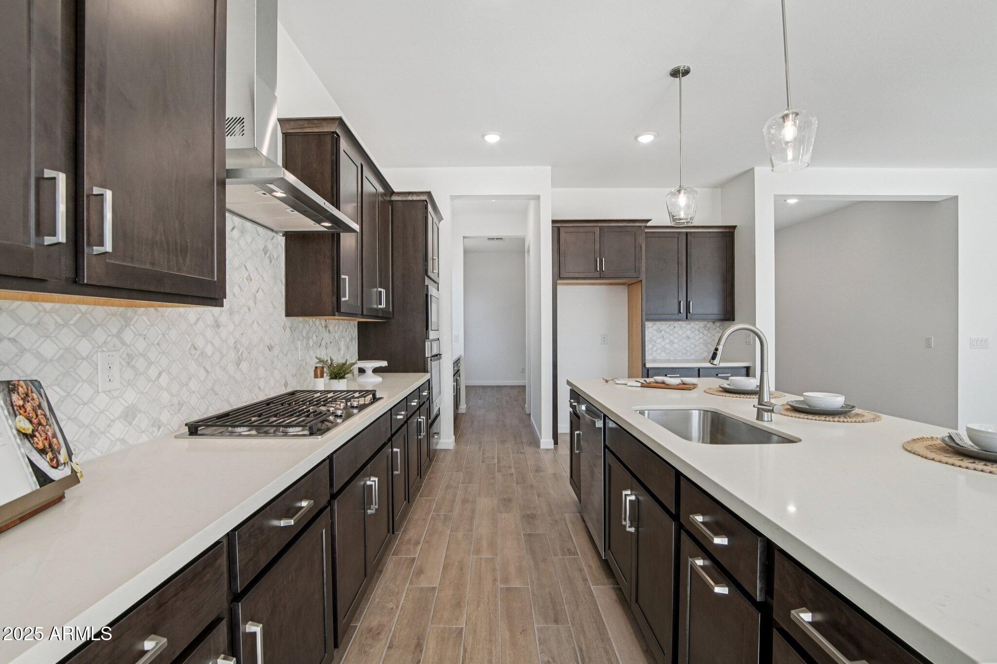 22725 East Saddle Way Queen Creek, AZ 85142 - Photo 15 of 48 a kitchen with stainless steel appliances a sink stove and cabinets