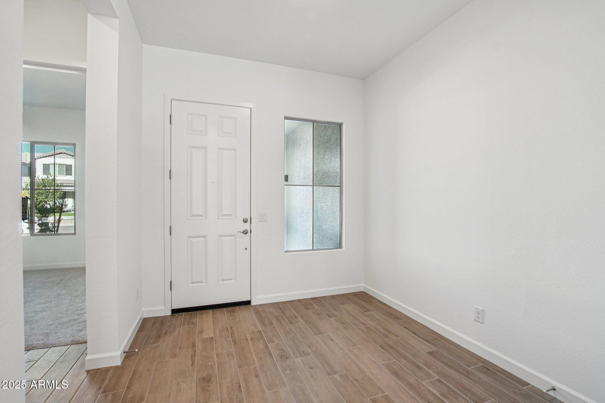 22725 East Saddle Way Queen Creek, AZ 85142 - Photo 17 of 48 an empty room with wooden floor and windows