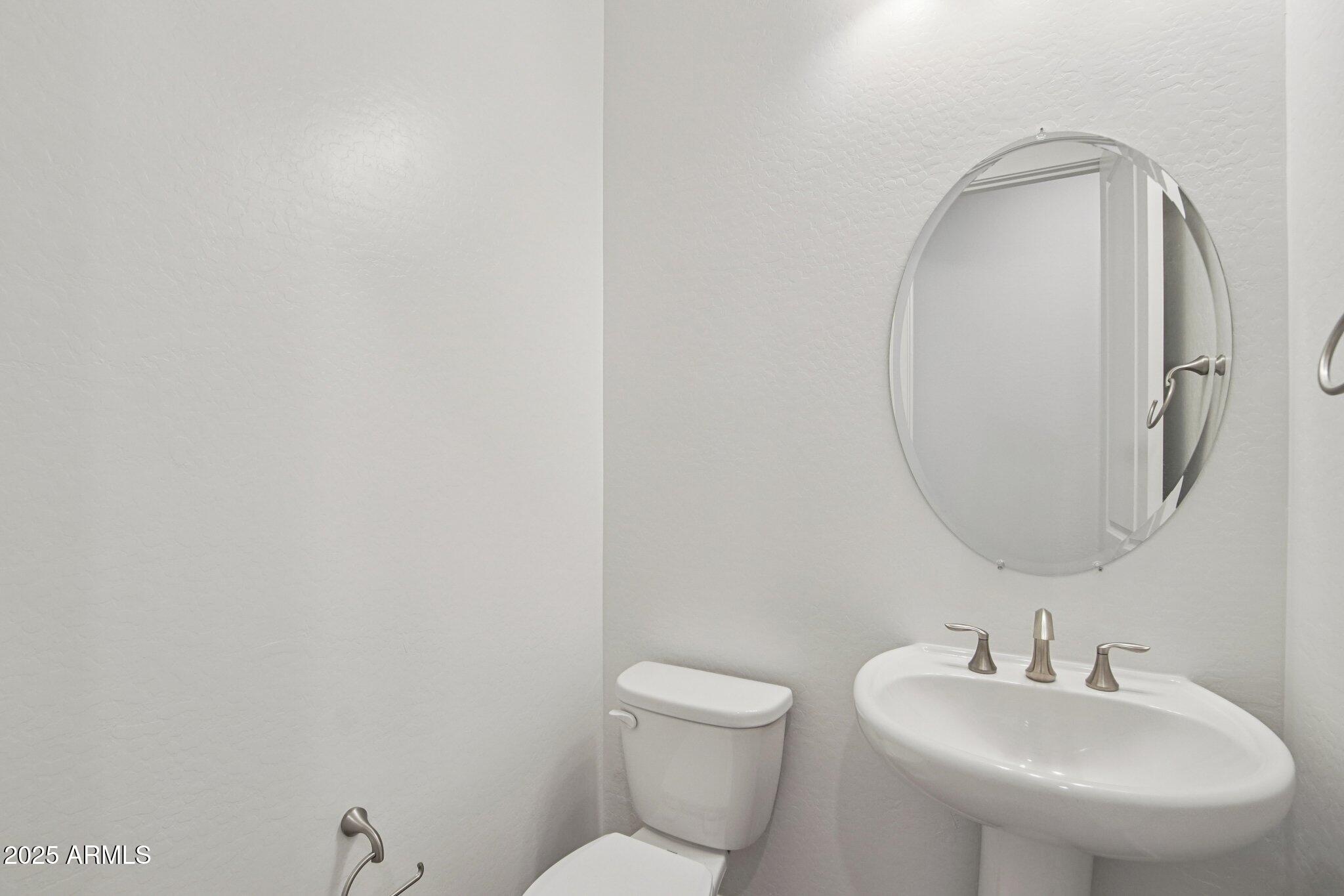 22725 East Saddle Way Queen Creek, AZ 85142 - Photo 23 of 48 a bathroom with a toilet sink and mirror
