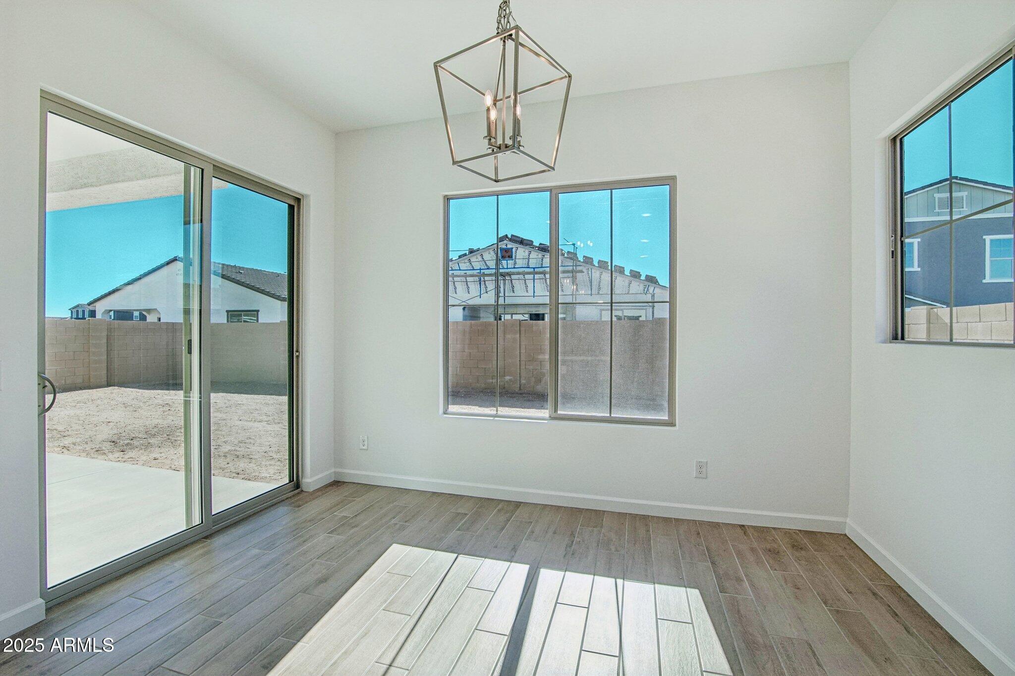 22725 East Saddle Way Queen Creek, AZ 85142 - Photo 31 of 48 a view of an empty room with wooden floor and a window