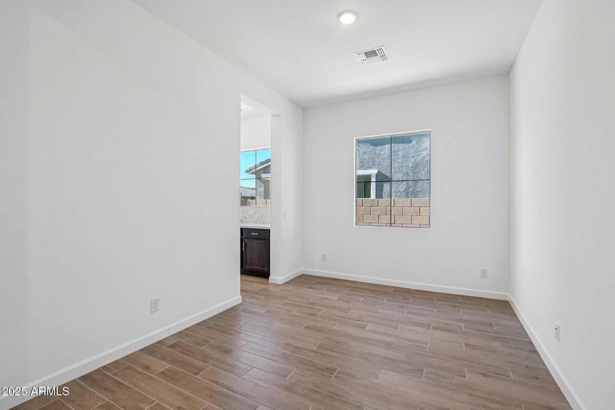 22725 East Saddle Way Queen Creek, AZ 85142 - Photo 7 of 48 an empty room with wooden floor and windows