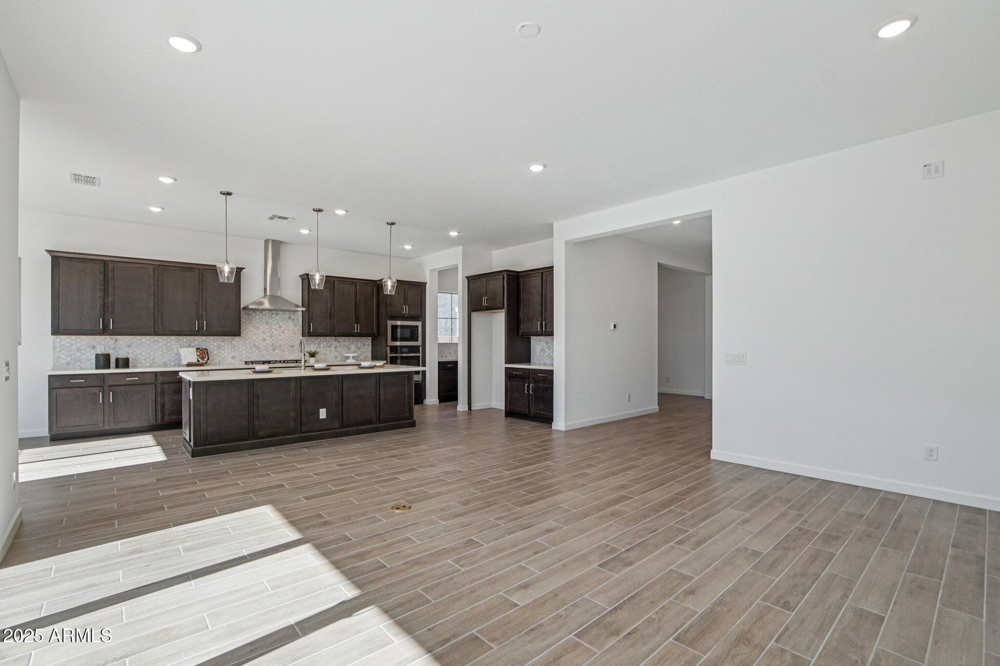 22725 East Saddle Way Queen Creek, AZ 85142 - Photo 10 of 48 a view of kitchen with kitchen island stainless steel appliances sink cabinets and stove top oven