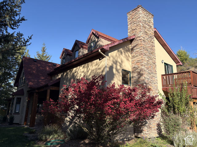 725 Canyon Road Smithfield, UT 84335 - Photo 74 of 100 Stucco exterior with a stone-clad chimney and a red shingle roof